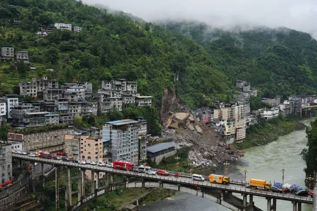  Rescue vehicles stand by on the bridge as rescuers conduct a search and rescue operation at the scene of a landslide in Pengshui County in southwestern China's Chongqing on Saturday, July 18, 2026. (AP) 