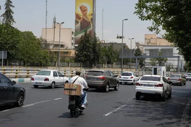  Vehicles drive past a billboard depicting the clenched fist of slain Iranian Supreme Leader Ali Khamenei, in Tehran, Iran, Tuesday, July 21, 2026. (AP)