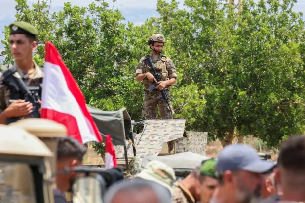 Lebanese soldiers ride military vehicles at the entrance to Zawtar al-Gharbiyeh, where the army deployed on Tuesday after an Israeli withdrawal. (Reuters)