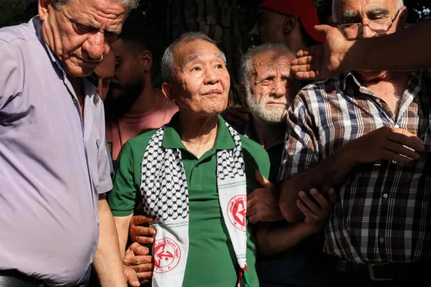كوزو أوكاموتو (في الوسط) العضو الوحيد الباقي على قيد الحياة من وحدة الكوماندوز المكونة من ثلاثة رجال «الجيش الأحمر الياباني» التي قتلت 26 شخصاً في هجوم على مطار اللد الإسرائيلي يوم 30 مايو 1972 يحضر حفلاً نظّمه مسلحون فلسطينيون لإحياء الذكرى الخمسين لهجوم اللد في إسرائيل... بيروت 30 مايو 2022 (أ.ف.ب)