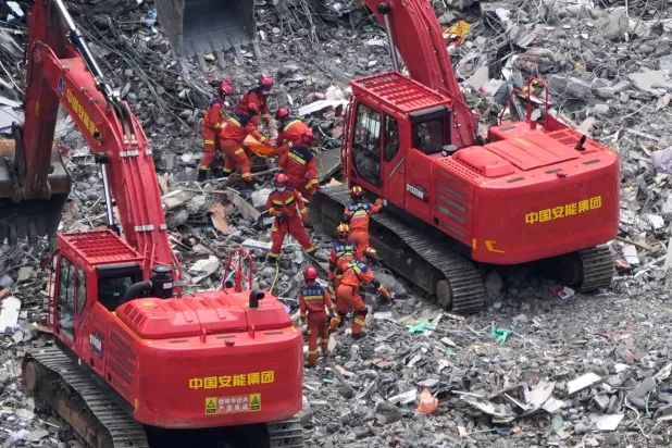 Rescuers recover a trapped victim from the rubble at the scene of a landslide in Pengshui County in southwestern China's Chongqing area on Sunday, July 19, 2026. (AP Photo/Andy Wong)