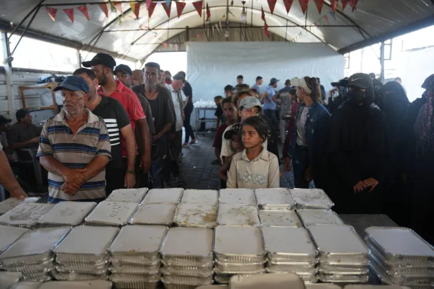 نازحون فلسطينيون ينتظرون الحصول على حصتهم من الطعام لدى مطعم جمعية في خان يونس جنوب غزة (أ.ب)