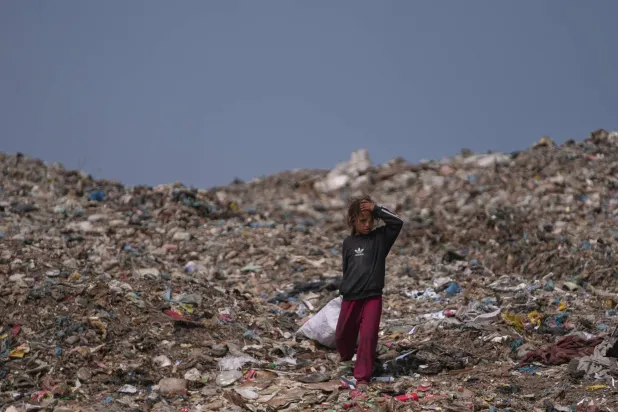 A Palestinian girl searches for reusable items at a landfill in Deir al-Balah, in the central Gaza Strip, Thursday, July 23, 2026. (AP Photo/Abdel Kareem Hana)