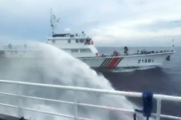 This handout screengrab taken on July 24, 2026 and released by the Philippine Coast Guard (PCG) shows a Chinese Coast Guard ship (back) firing water canon on a Philippine Bureau of Fisheries and Aquatic Resources (BFAR) ship near Scarborough Shoal, in the disputed South China Sea. (Handout / Philippine Coast Guard (PCG) / AFP) 