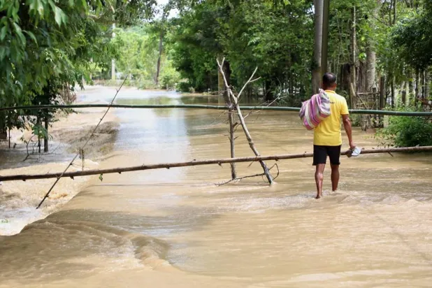 A man wades through the flood water in Teok village in upper Assam, India, Friday, July 24, 2026. (AP) 