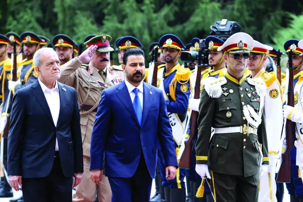 رئيس الوزراء العراقي علي الزيدي (وسط) يستعرض مع الرئيس الإيراني مسعود بزشكيان حرس الشرف (الرئاسة الإيرانية)