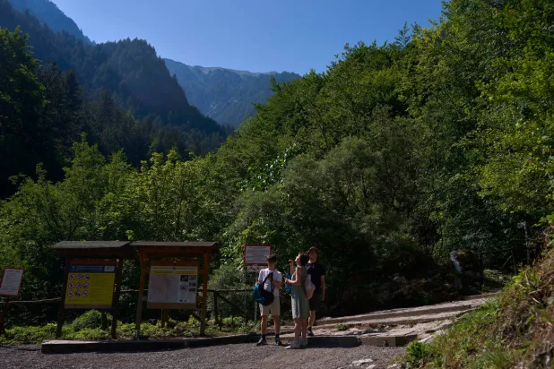 Visitors stand at the Prionia trailhead on Mount Olympus in northern Greece, Wednesday, July 15, 2026. (AP Photo/Petros Giannakouris)