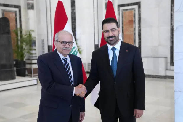 This handout picture taken and released on July 26, 2026 by the Iraqi Prime Minister's Office shows Iraq's Prime Minister Ali al-Zaidi (R) shaking hands with Lebanon's Prime Minister Nawaf Salam during their meeting in Baghdad. (Photo by IRAQI PRIME MINISTER'S PRESS OFFICE / AFP)