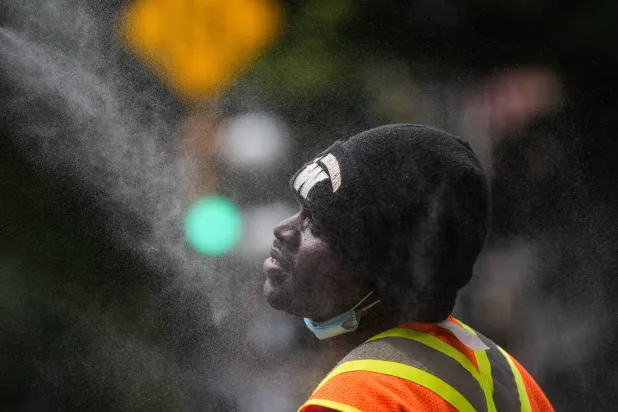 A man cools off at a misting station in the Downtown Eastside of Vancouver, British Columbia, Canada, on Wednesday, July 22, 2026. (Darryl Dyck/The Canadian Press via AP)