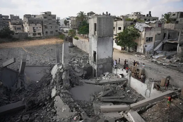 Palestinians inspect a destroyed building at the site of an Israeli airstrike, at al-Bureij refugee camp, central Gaza Strip, Friday, July 24, 2026. (AP)