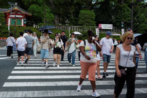  People use portable fans to cool themselves on the street as the Japanese government issued a heatstroke alert in Tokyo and other prefectures due to a heatwave, in Kyoto, western Japan July 23, 2026. (Reuters)