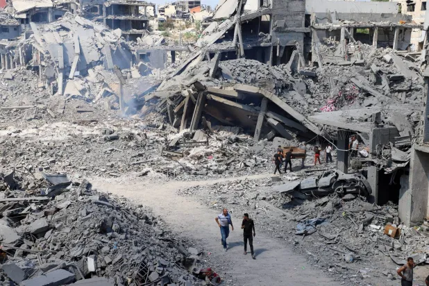  Palestinians inspect a site of an Israeli strike on a storage facility, that had been warned by the Israeli military to evacuate earlier on Sunday before it was struck later the same day, in Gaza City, July 27, 2026. (Reuters)