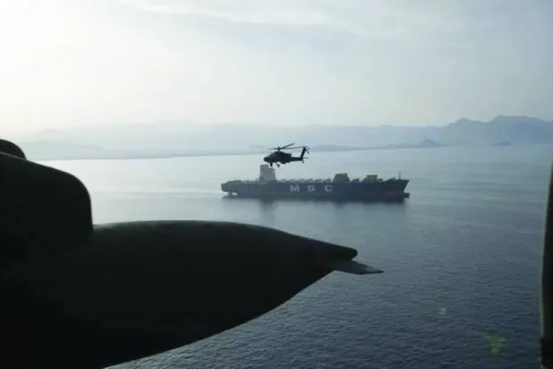 Cuma günü Hürmüz Boğazı üzerinde uçan ABD'ye ait AH-64 model bir Apache helikopteri (CENTCOM)