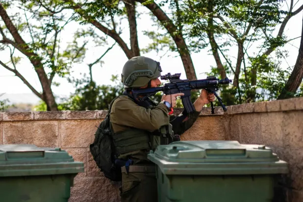 "Hizbullah"a ait bir İHA’nın kuzey sınırı boyunca düzenlediği saldırının ardından, Lübnan sınırına yakın bir yerde siper alan İsrail askeri, etrafı gözetliyor (AFP)