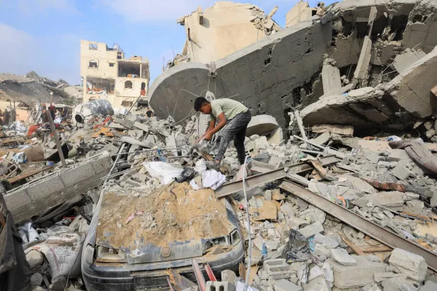 طفل فلسطيني يتفقد موقع الغارة الإسرائيلية التي استهدفت مدينة غزة (رويترز)