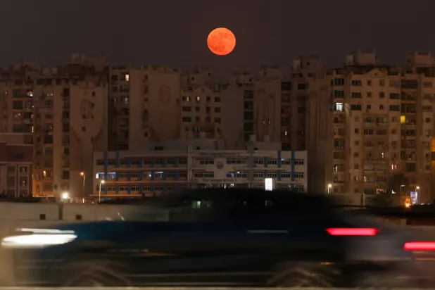 The full moon known as the "Buck Moon" rises over residential buildings in the capital city of Cairo, Egypt, July 29, 2026. (Reuters) 