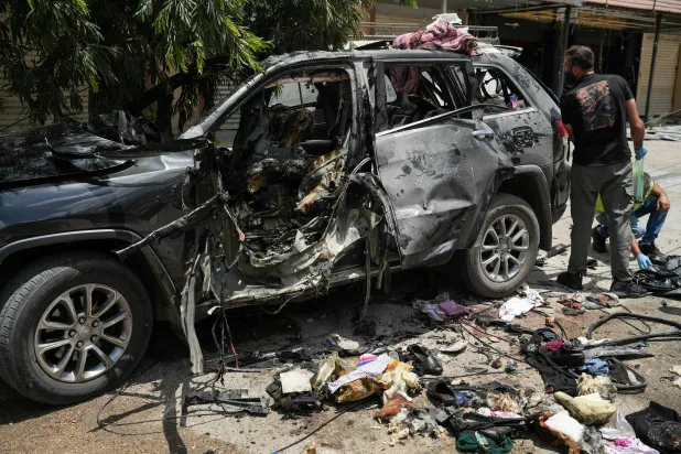 First responders inspect the wreckage of a car targeted by an Israeli strike in Nabatieh on July 6, 2026. (AFP)