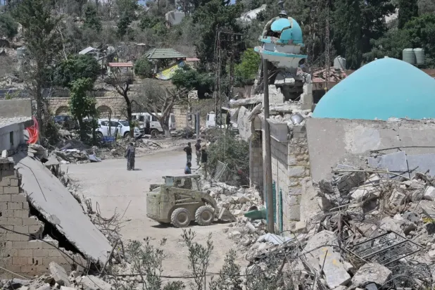 Lübnan ordusuna ait bir buldozer, İsrail tarafından Güney Lübnan'da yıkılan Zevtar al-Garbiye kasabasındaki caminin kubbesinin altındaki molozları temizliyor. (Şarku’l Avsat)