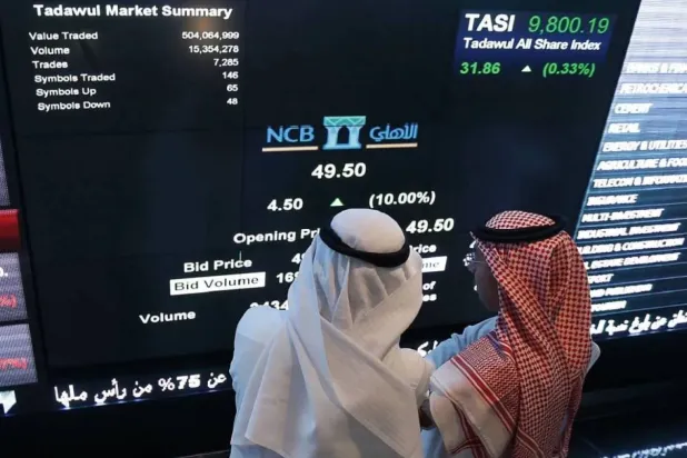 مستثمران يتابعان تحركات الأسهم في السوق السعودية (أ.ف.ب)