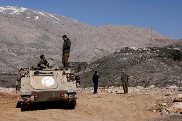 In this file photo dated February 27, 2025, Israeli soldiers stand atop an armored personnel carrier in the buffer zone which separates the Israeli-annexed Golan Heights and Syria, near the Druze village of Majdal Shams. AFP) 