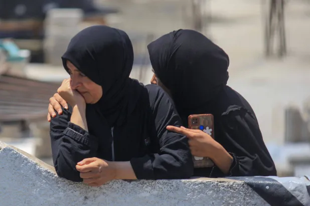 فلسطينيات خلال جنازة لرفات ١١٢ فرداً من عائلة أبو ناصر الذين قُتلوا في هجوم إسرائيلي وقد تم انتشال جثث الضحايا بعد بقائها تحت الأنقاض لأشهر (د.ب.أ)