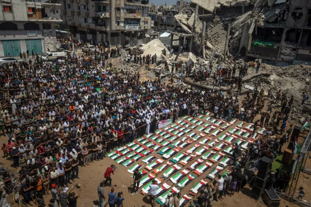 فلسطينيون يشيعون جثامين 112 شخصاً من عشيرة واحدة بشرق مدينة غزة يوم الثلاثاء (إ.ب.أ)