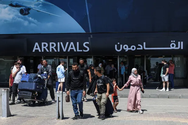 Passengers with their luggage walk at Damascus International Airport after arriving on the inaugural flight from Germany operated by German carrier LEAV Aviation in Damascus, Syria, 29 July 2026. (EPA)