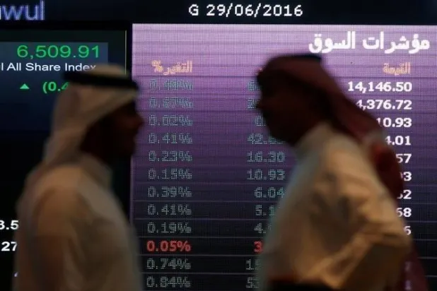 رجلان يتحدثان في السوق السعودية (رويترز)