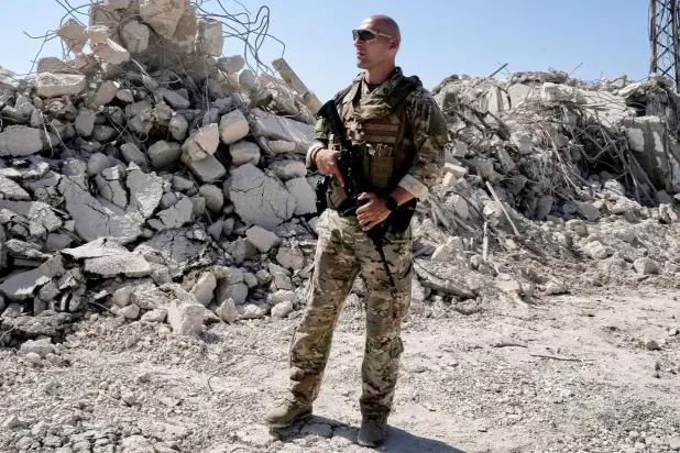 Lübnan ordusuna bağlı bir asker, Lübnan'ın güneyindeki Zevtar al-Garbiye kasabasında yıkılan binaların enkazının önünde, (AP)