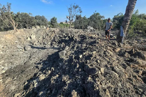 A man stands by a crater left by an overnight Israeli airstrike that targeted a house in the area of Burj al-Shamali, near Tyre, on August 6, 2026. (Photo by Kawnat HAJU / AFP) / 