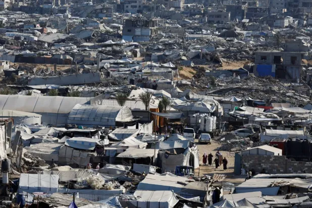 فلسطينيون يسيرون وسط أنقاض مبانٍ سكنية دُمّرت خلال الحرب في مخيم جباليا للاجئين شمال قطاع غزة (رويترز)