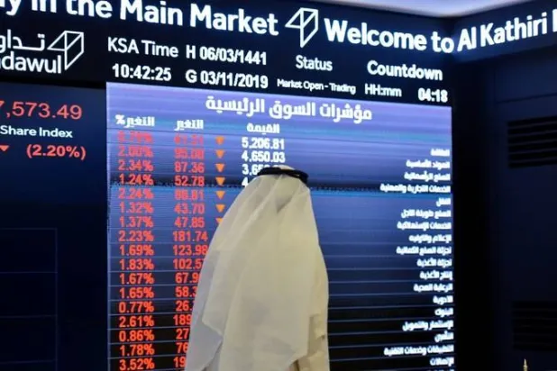 رجل يتابع الأسهم في السوق السعودية (أ.ف.ب)