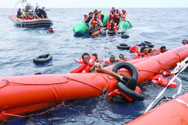 مهاجرون تم إنقاذهم في وقت سابق من الموت بعد غرق مركبهم الذي انطلق من سواحل ليبيا باتجاه أوروبا (أ.ب)