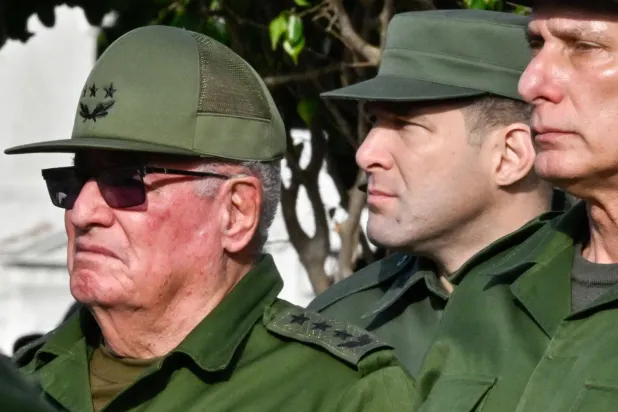 Küba Devlet Başkanı Miguel Díaz-Canel (sağda), eski Devlet Başkanı Raúl Castro'nun torunu Albay Raúl Guillermo Rodríguez Castro (ortada) ve Silahlı Kuvvetler Bakanı General Álvaro López Miera, ABD'nin Venezuela'ya yönelik müdahalesi sırasında hayatını kaybeden 32 Kübalı askerin cenaze törenine katılırken. (AFP)