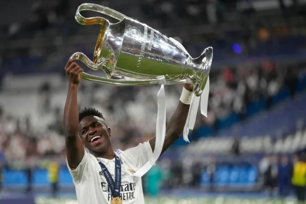 Real Madrid's Vinicius Junior holds up the trophy after winning the Champions League final soccer match between Liverpool and Real Madrid in Saint Denis near Paris, May 29, 2022. (AP) 