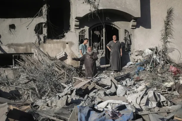 Filistinliler, Deyr el-Belah'ta İsrail saldırılarının hedefi olan hasarlı binaları inceliyor (AFP)