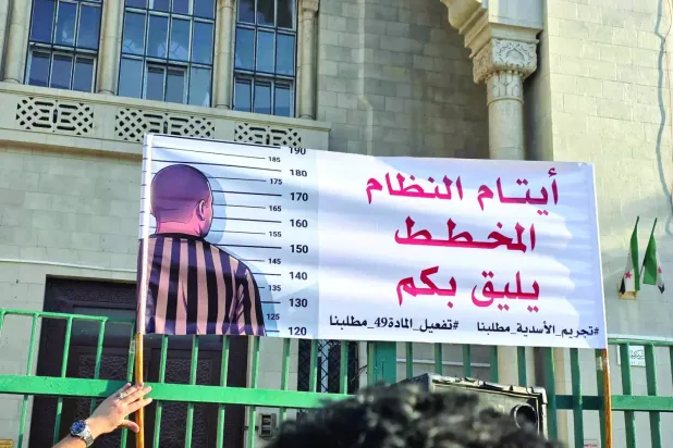 Geçtiğimiz haziran ayında Şam'daki "Adalet Sarayı" önünde toplanan aktivistler, Esed döneminin sembollerinin suç kapsamına alınmasını talep etmişti, (Facebook)