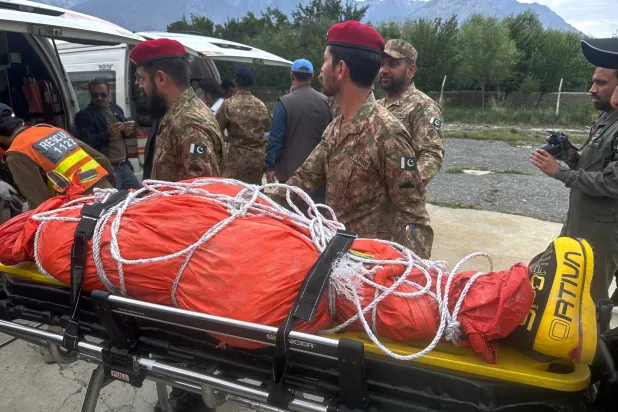 Pakistani army soldiers prepare to load into an ambulance, the body of renowned British-Nepali mountaineer Nirmal Purja, that was recovered from Broad Peak nearly a week after an avalanche swept away a 10-member international expedition, upon arrival at a military base in Skardu, in northern Pakistan, Thursday, Aug. 6, 2026. (AP Photo/ M.H. Balti)