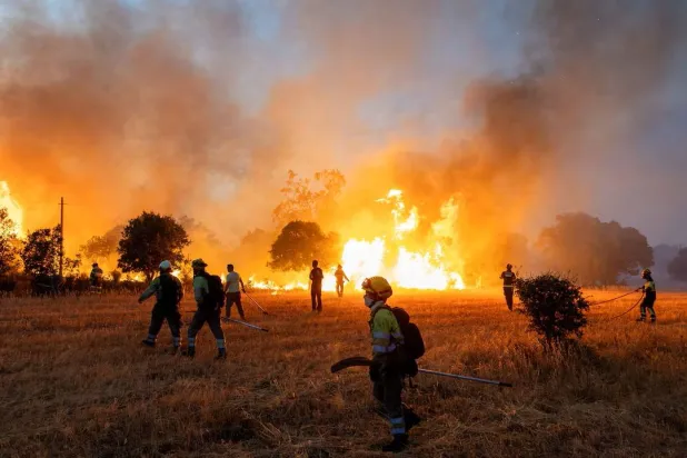 Residents and firefighters work to extinguish an advancing wildfire near Formariz in Zamora province, Spain, July 29, 2026. REUTERS/Umit Bektas/File Photo
