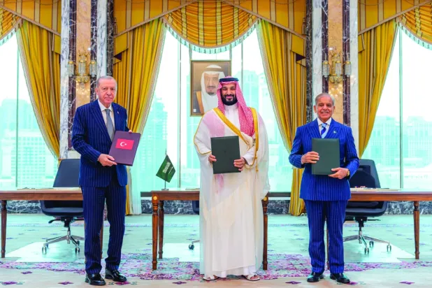   امیر محمد بن سلمان، رئیس‌جمهوری اردوغان و نخست‌وزیر شهباز شریف را پس از امضای «توافق‌نامه مکه برای دفاع مشترک» در میان گرفته است (واس)