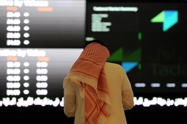 مستثمر يتابع الأسهم في السوق السعودية (أ.ف.ب)