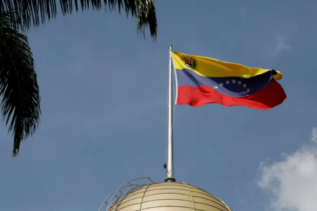 Karakas'taki Ulusal Meclis binasının üzerinde dalgalanan Venezuela bayrağı (Reuters)