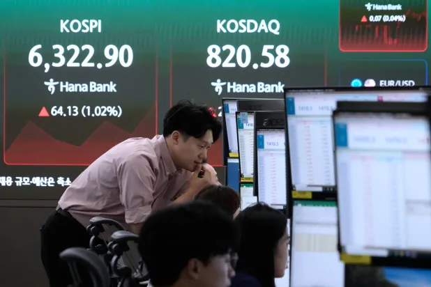 متداول يتابع شاشات التداول في غرفة تداول العملات الأجنبية بمقر بنك هانا في سيول (أ.ب)