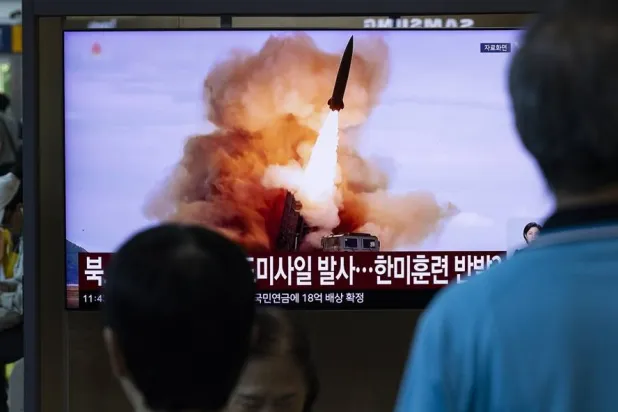 People watch a news broadcast on a television screen showing a report on a missile launch, at a railway station in Seoul, South Korea, 12 August 2026. (EPA)