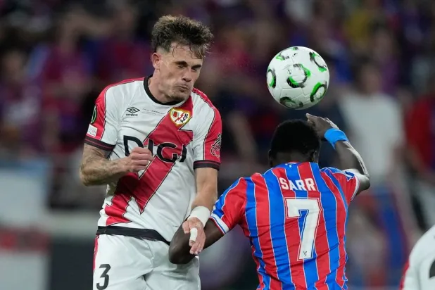 Rayo's Pep Chavarria and Crystal Palace's Ismaila Sarr jump for the ball during the Europa Conference League final soccer match between Crystal Palace and Rayo Vallecano in Leipzig, Germany, May 27, 2026. (AP)