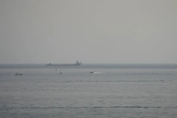 Boats and a vessel in the Strait of Hormuz, as seen from Musandam, Oman, August 3, 2026. (Reuters)