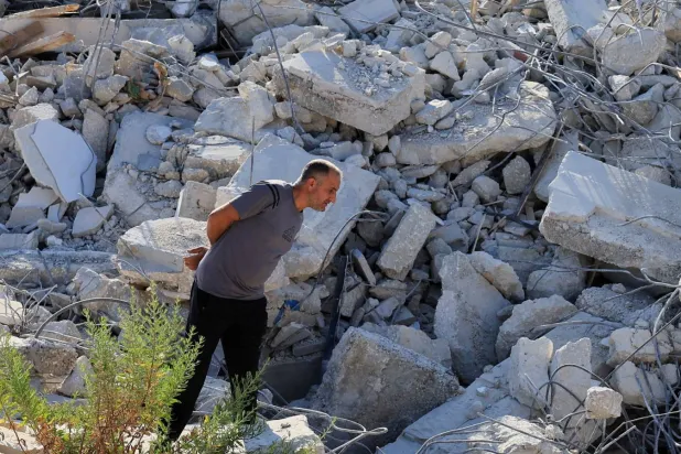 فلسطيني يتفقد الأضرار بعد أن هدمت آليات إسرائيلية مبنى فلسطينياً قرب بيت لحم في الضفة الغربية المحتلة (رويترز)