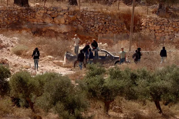 Israeli settlers besiege a Palestinian home for the fourth consecutive day in the town of Qusra, south of Nablus, 12 August 2026. (EPA)