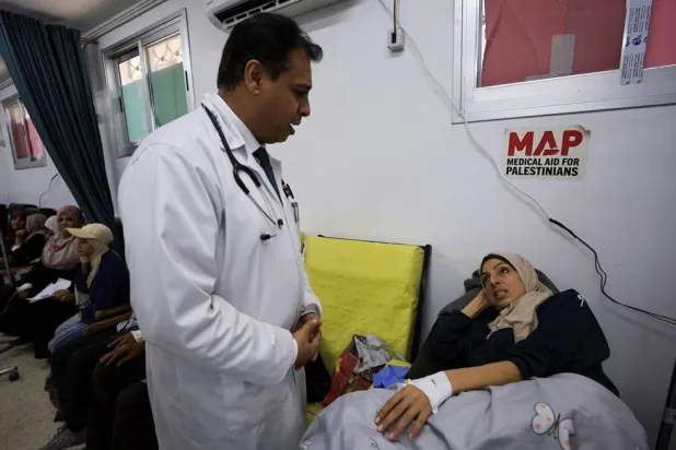 Palestinian cancer patient Elham Al-Sakafi, 38, speaks to a doctor after receiving nutritional intravenous fluids at Al-Shifa Hospital in Gaza City, August 6, 2026, according to medics. (Reuters)