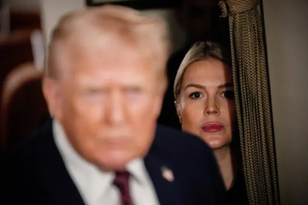 FILE - White House press secretary Karoline Leavitt watches as President Donald Trump speak to reporters while in flight on Air Force One to Joint Base Andrews, Md., Jan. 11, 2026. (AP Photo/Julia Demaree Nikhinson, File)